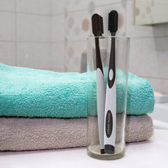 Adult with sensitive teeth using charcoal toothbrush