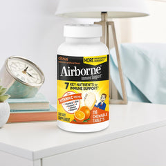 Citrus-flavored Airborne vitamin C + zinc chewables with bottle and tablets