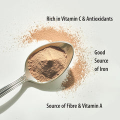 Amla powder being added to a smoothie