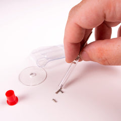 Close-up of tiny replacement screws and screwdriver