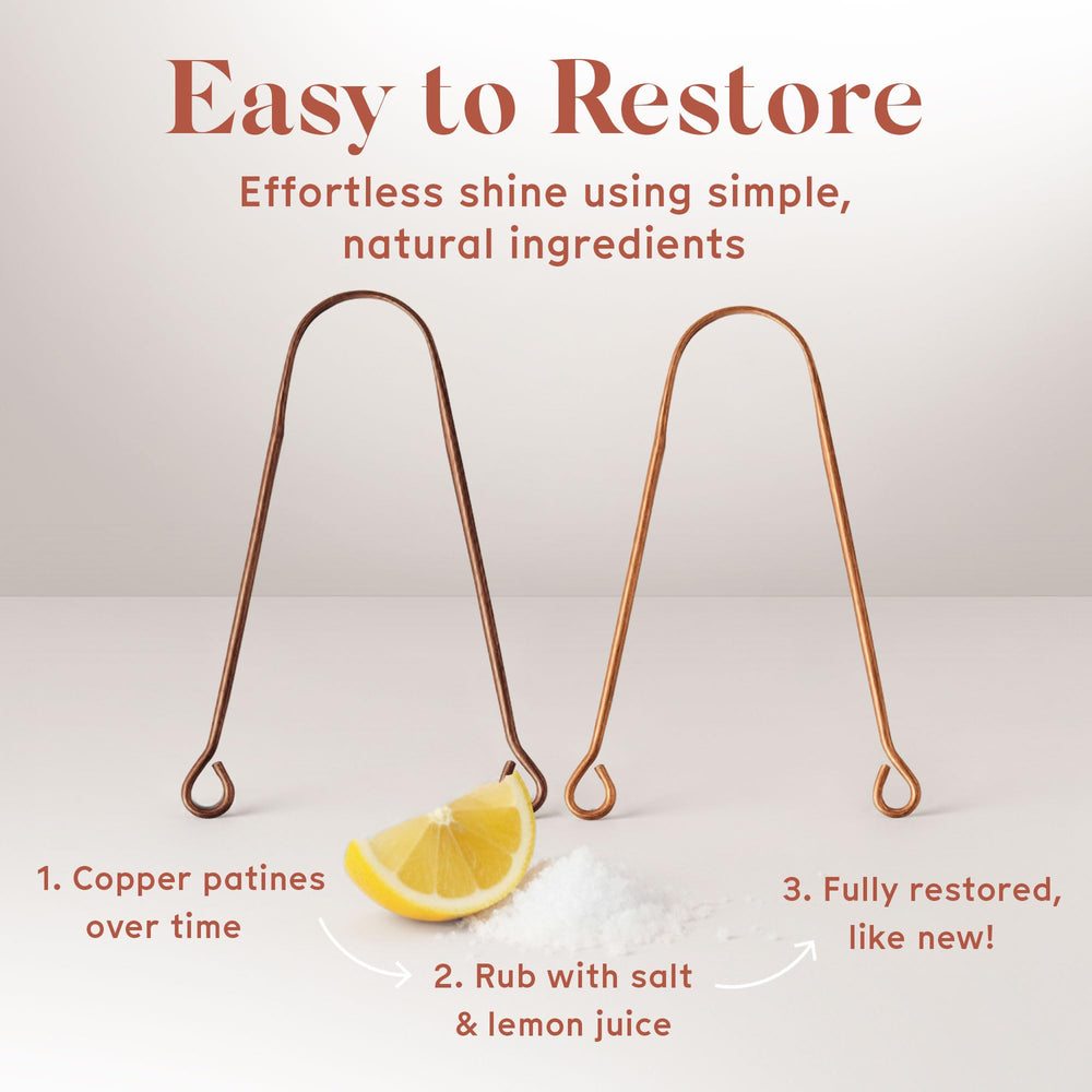 Hands holding copper tongue scraper for oral care