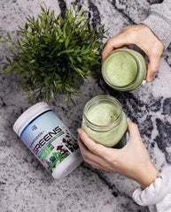 Glass of pink-green smoothie with strawberry banana garnish