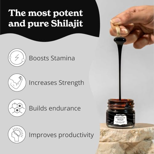 Copper spoon scooping shilajit resin from the jar
