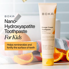 Toothpaste tube showing orange cream flavor for kids