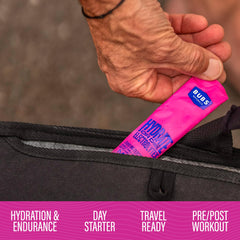 Close-up pouring electrolyte packet into water for fast hydration.