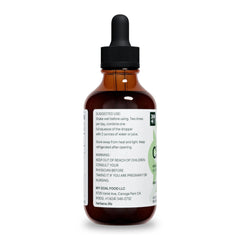 Glass with cilantro tincture next to a water bottle for dosage