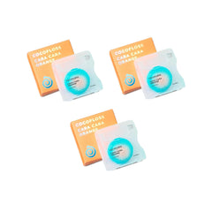 Close-up of Cocofloss woven dental floss with orange scent, waxed and expanding