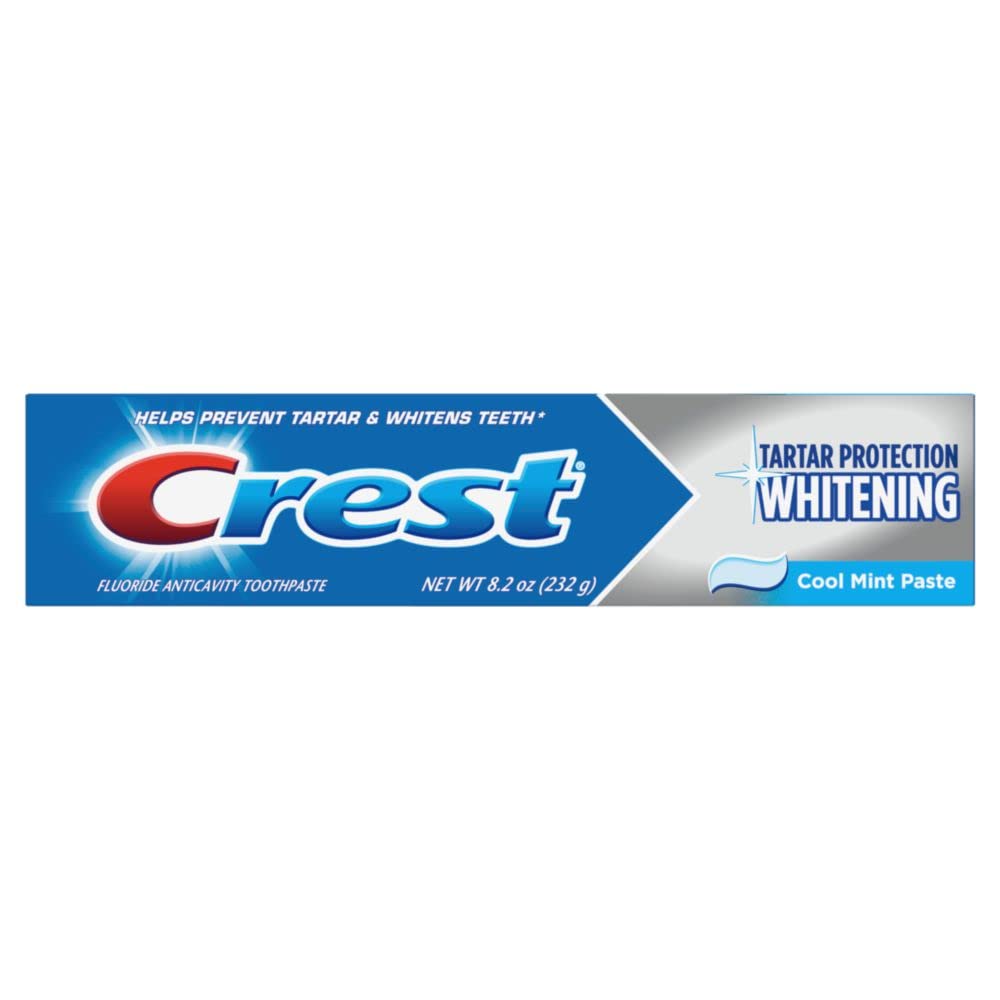 Crest toothpaste tube beside packaging on white