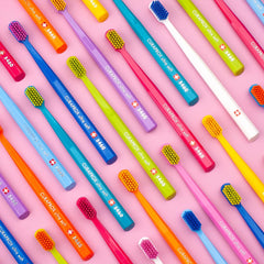 Lifestyle shot of orange-white Curaprox toothbrush in a bathroom setting