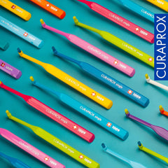 Blue Curaprox single-tuft toothbrush with soft bristles on white background