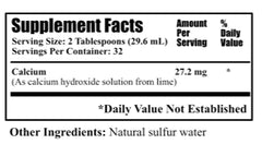 Measuring two tablespoons of Daily's Lime Water for calcium dosage