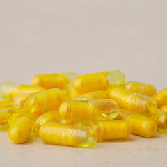 Close-up of turmeric essential oil and turmeric extract with dual chamber capsules