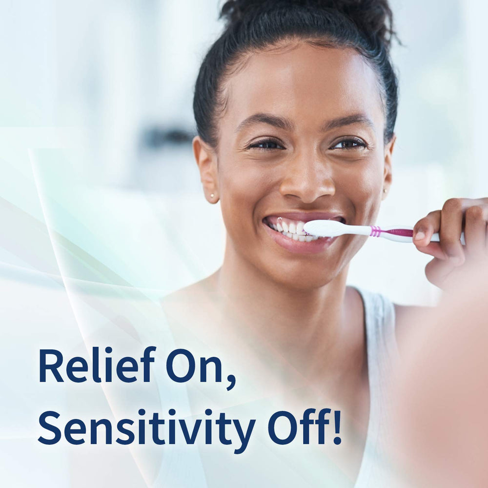 Mint Breeze Enamelon toothpaste tubes beside a glass of water