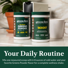 Greens First Boost shake next to fresh fruit on a kitchen counter.
