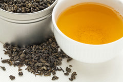 Cup of brewed gunpowder green tea with steam