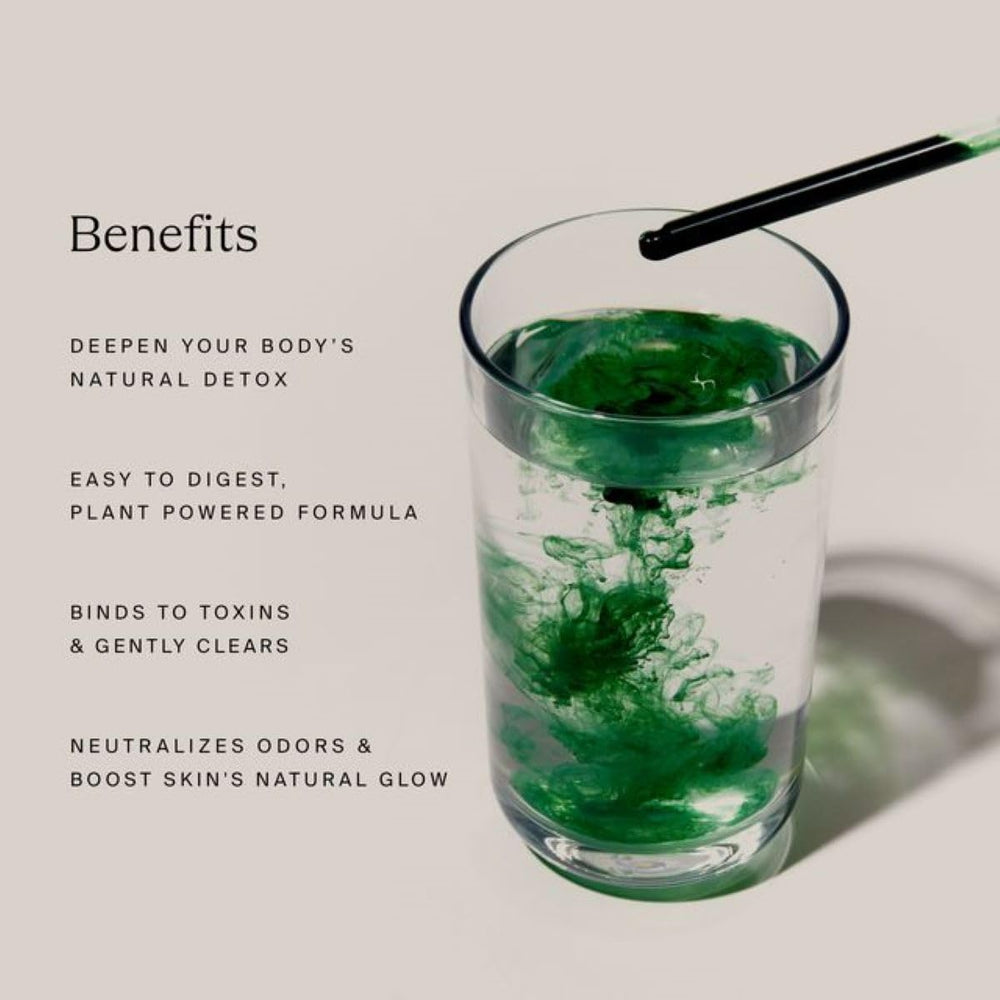 Dropper releasing detox drops into a glass of water