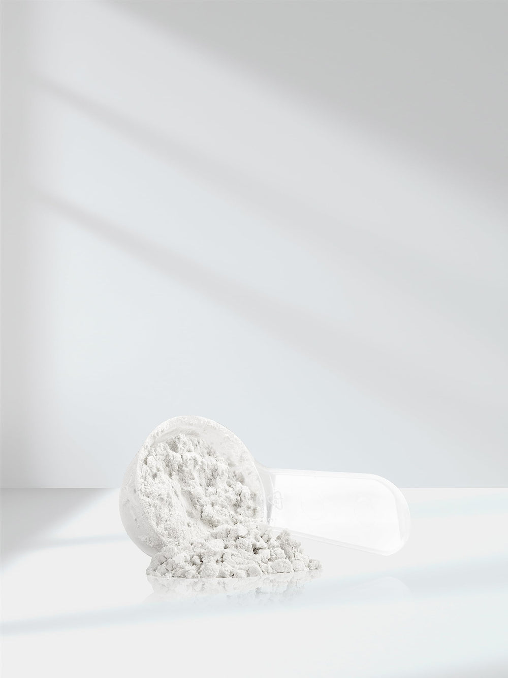 Product packaging and scoop beside jar on clean surface