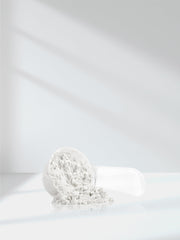 Product packaging and scoop beside jar on clean surface