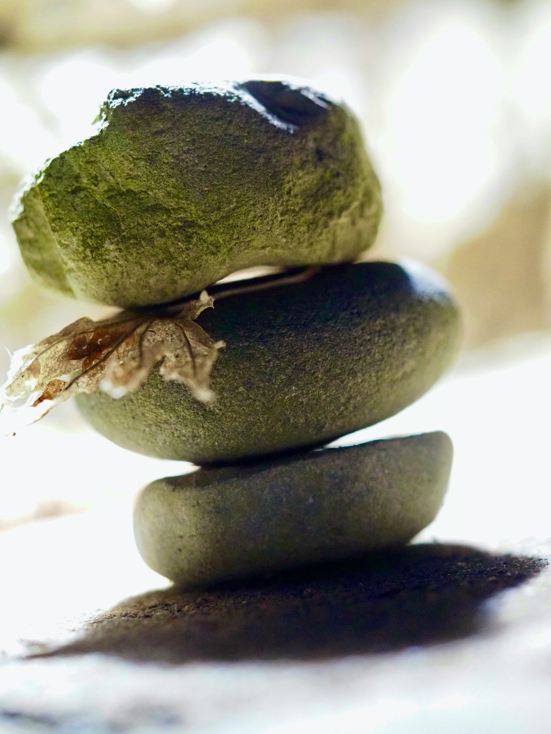 Three stacked green stones with a blurred background
