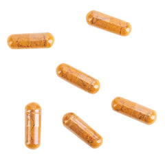 Turmeric root and capsules arranged with bottle