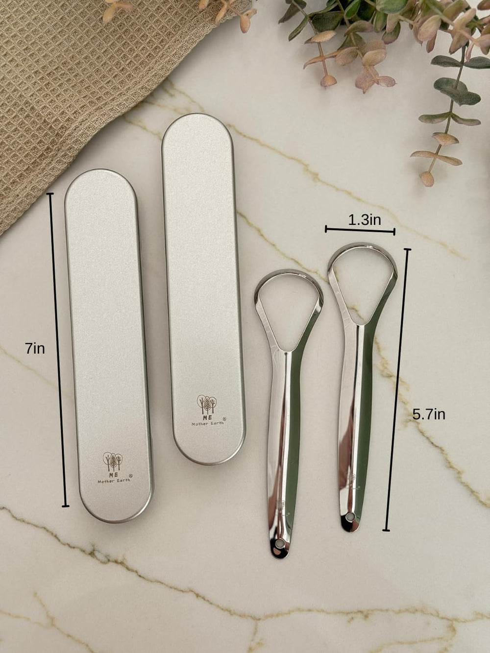 Close-up of a stainless steel tongue scraper with a metal travel case