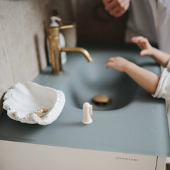 Fingertip design of Mushie finger toothbrush for gentle cleaning