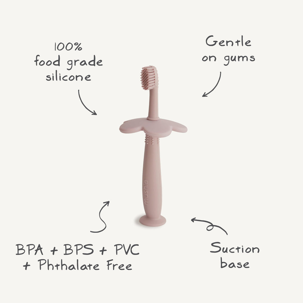 Care instructions image: washing Mushie Flower Toothbrush with warm, soapy water