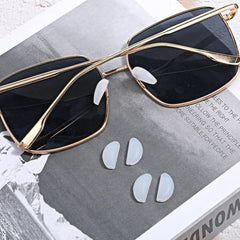 Flat lay of 10 white silicone nose pads for rimless frames