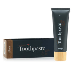 Smiling person brushing teeth with Nudge Watermelon toothpaste