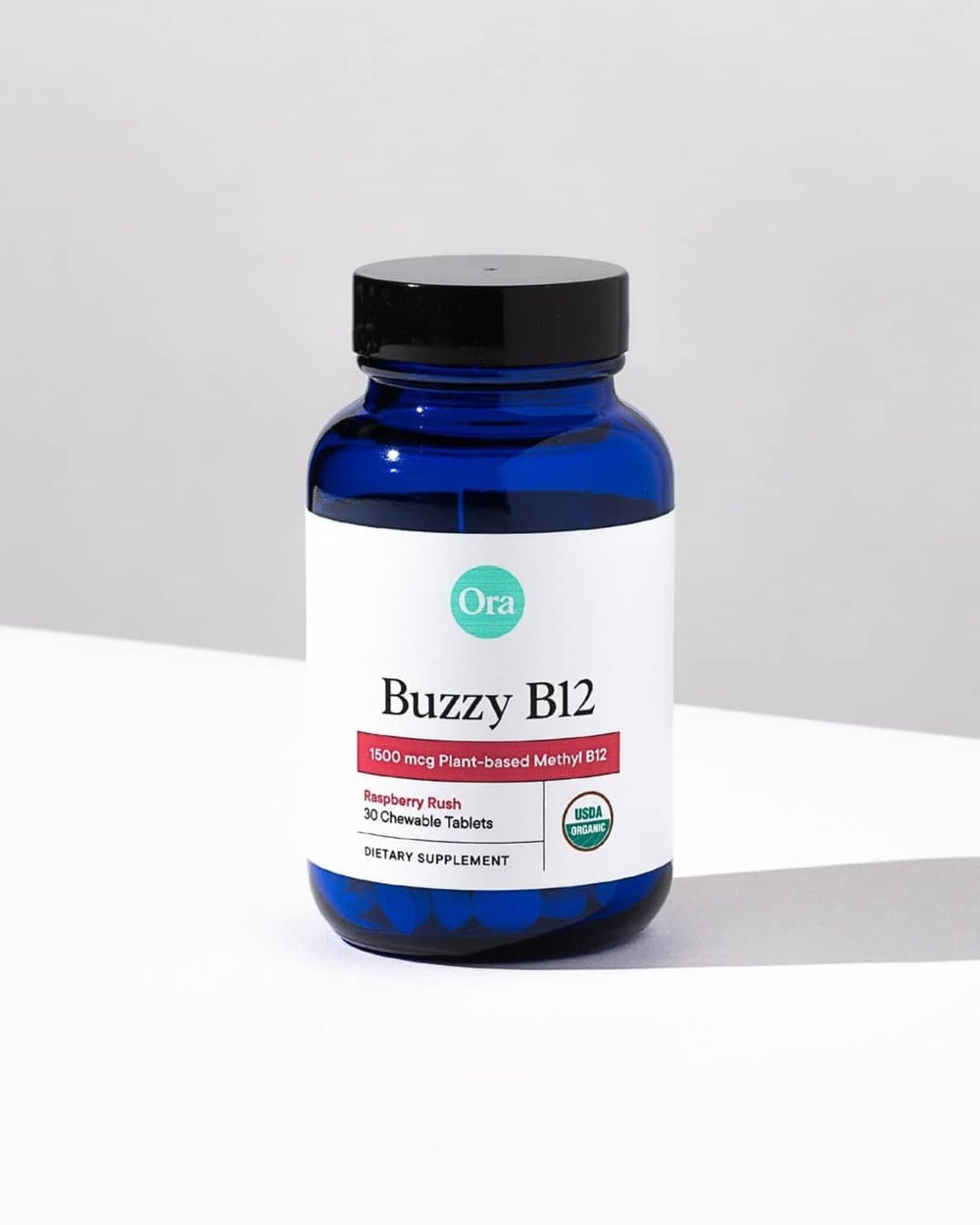 Lifestyle image of a person taking Ora Organic B12 raspberry chewable