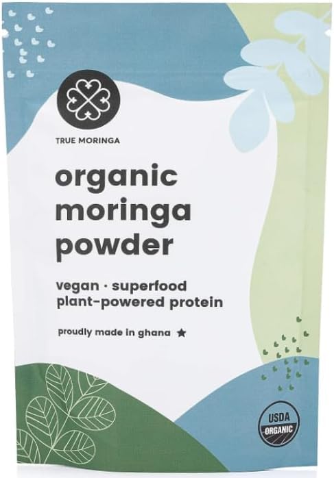 Organic Moringa Powder in a scoop on white background