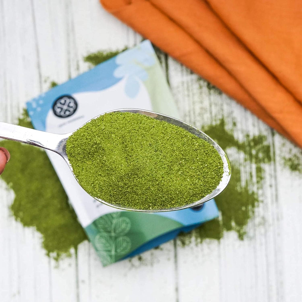 Moringa leaves and powder with measuring spoon