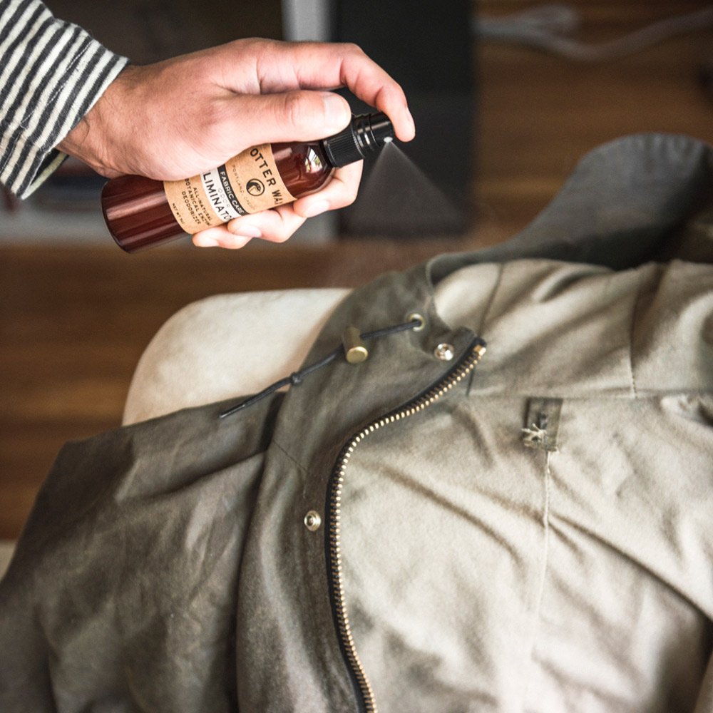 Spray application of Otter Wax Odor Eliminator on waxed canvas gear