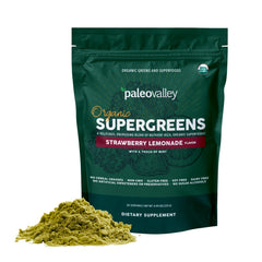 Scoop of Paleovalley Organic Supergreens powder beside a glass