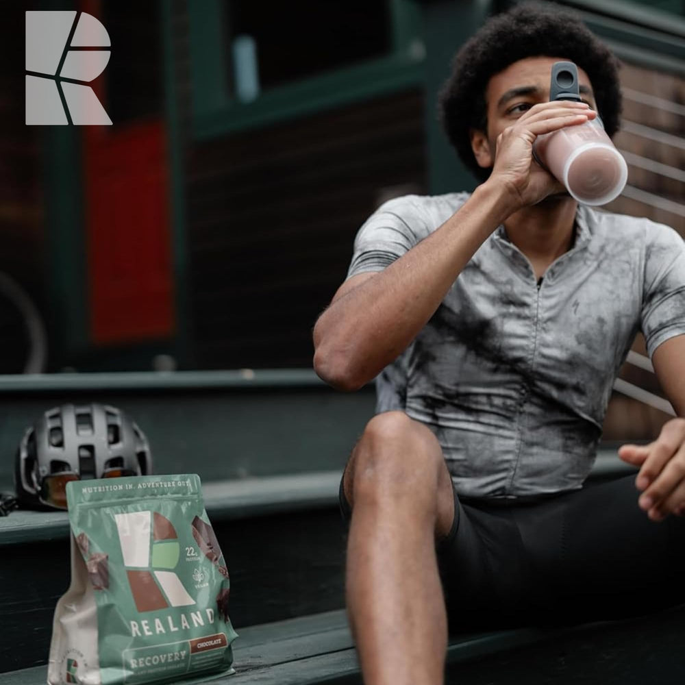 Realand Plant Protein chocolate tub image emphasizes rich cocoa flavor