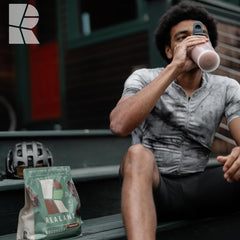 Realand Recovery Protein chocolate shake glass highlights smooth vegan formula