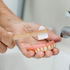 Illustration of dentures, retainers and aligners being cleaned with kit