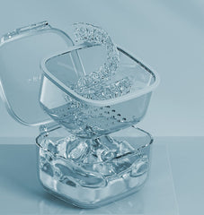 Open blue denture bath case showing drain tray