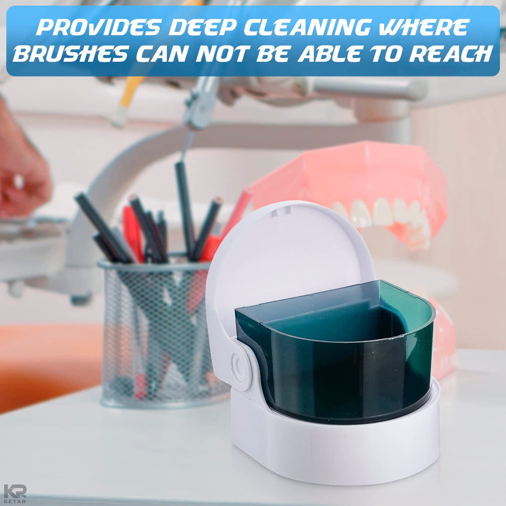 Portable denture cleaner powered by batteries in use