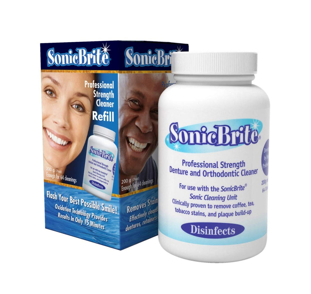 Close-up of stained denture being cleaned with SonicBrite powder