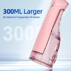 Compact portable water flosser in pink with nozzle attached
