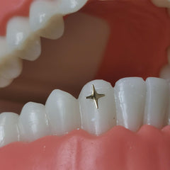 Silver-toned tooth gems close-up