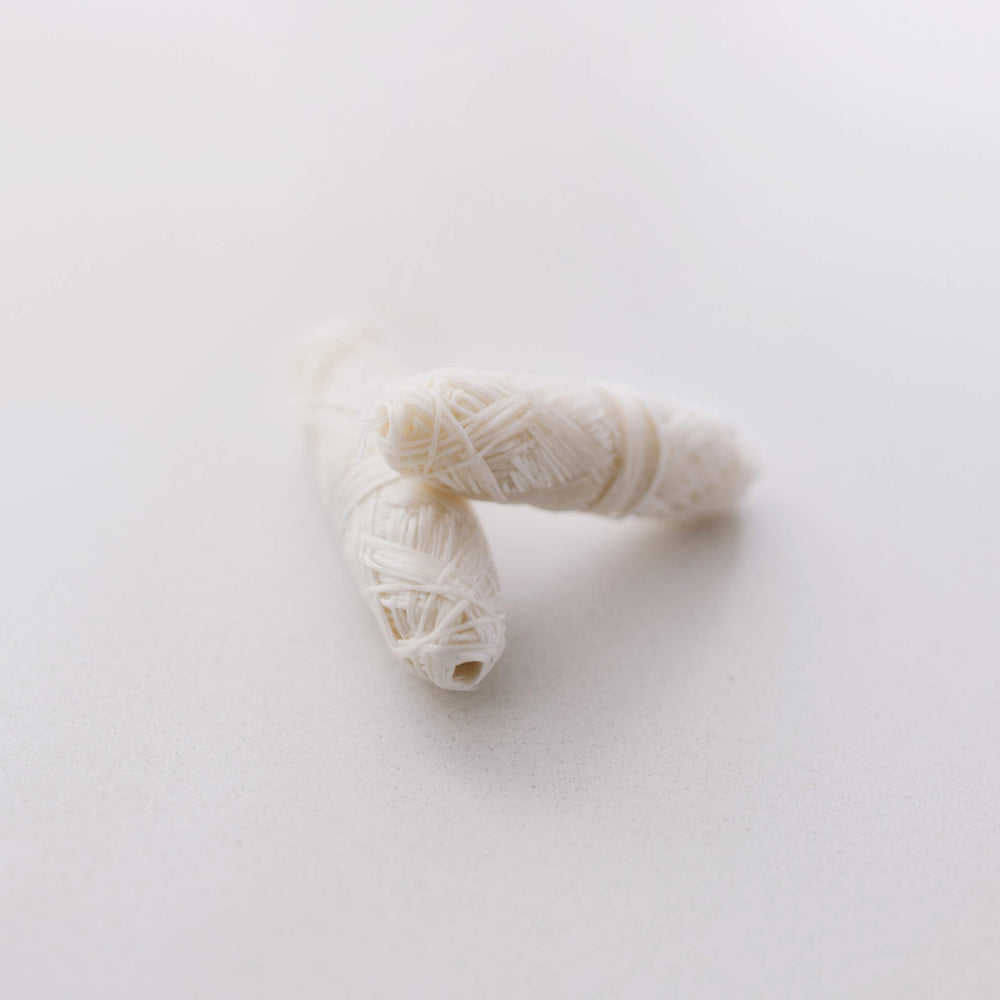 Close-up of silk floss spools coated with plant-based Candelilla wax