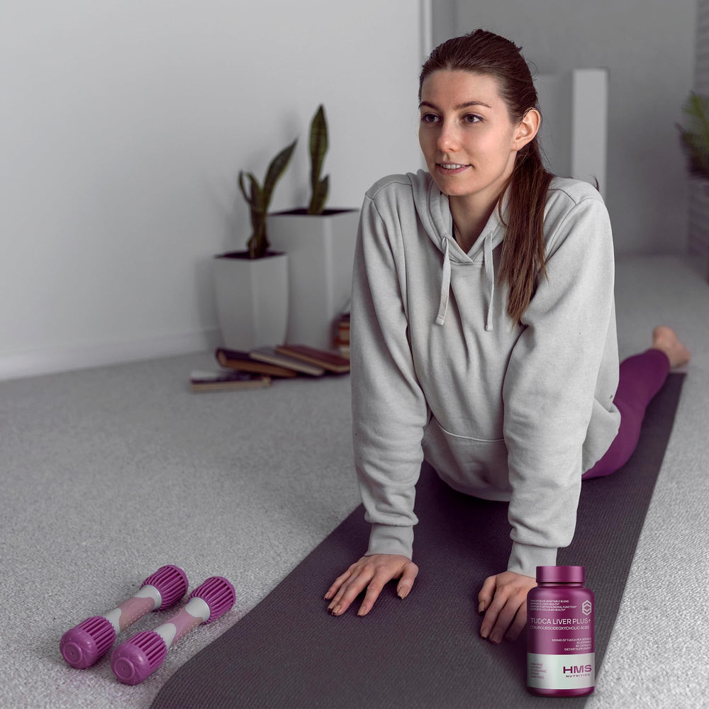 Lifestyle shot of a person taking TUDCA Liver Plus+ capsules with water