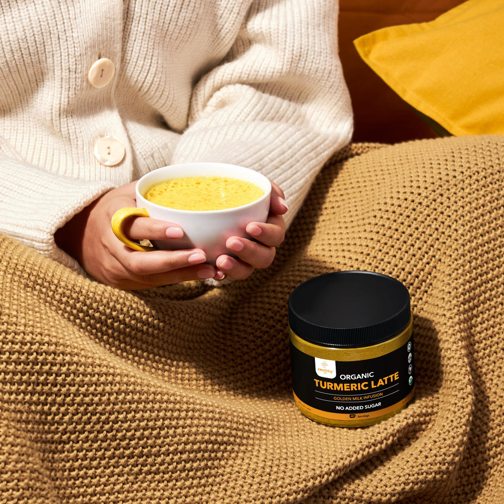 Spoon with turmeric latte powder over a bowl