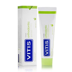 Person brushing braces with Vitis Orthodontic Toothpaste 100ml