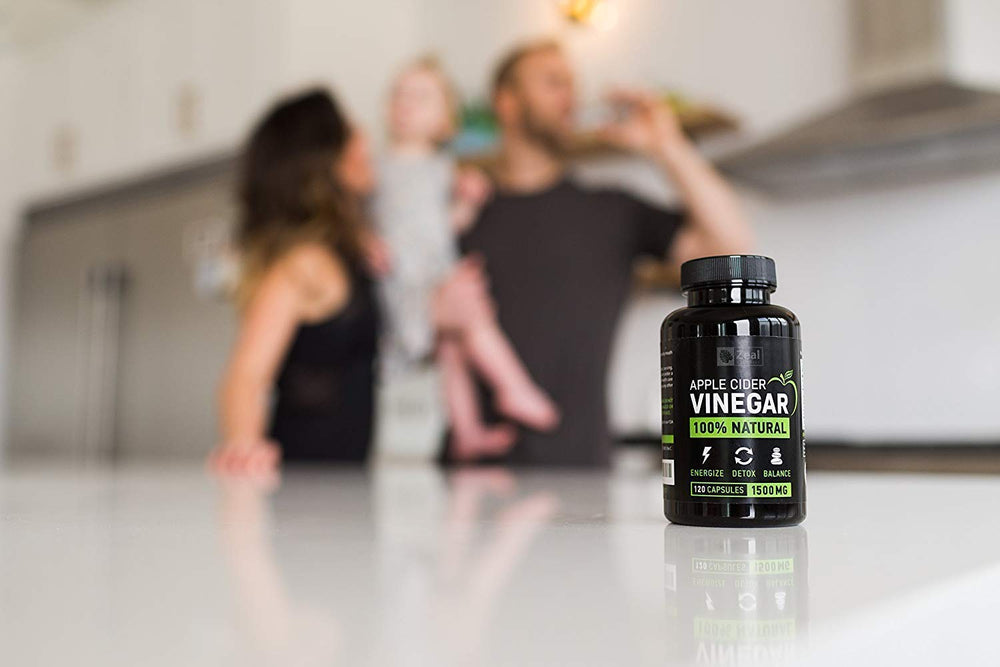 Zeal Naturals ACV capsules with glass of water for convenient daily wellness ritual.