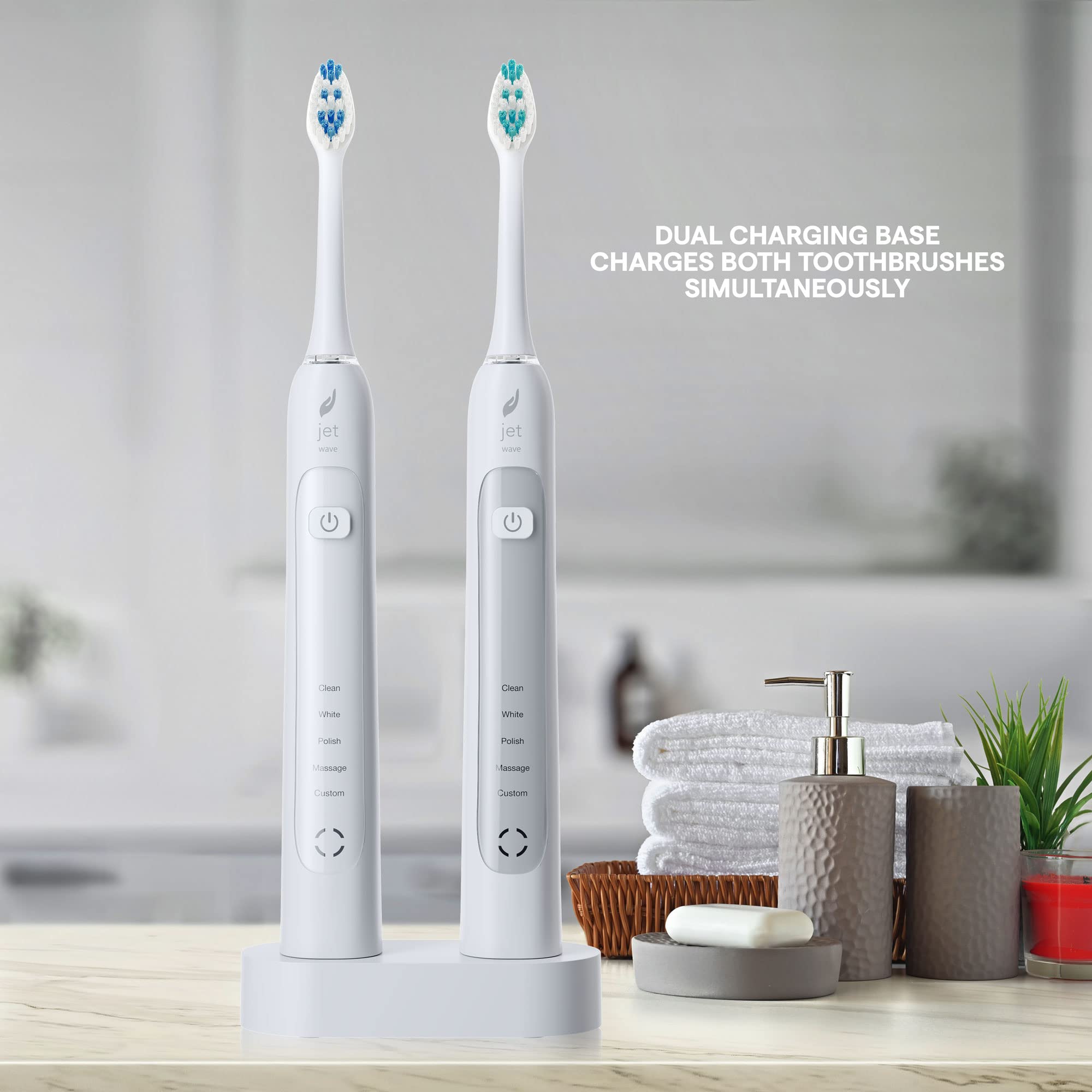 Two white Acteh Sonic Toothbrush handles with charging base