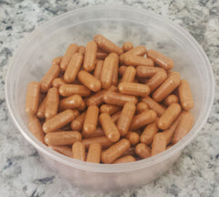 Supplement bottle with capsules and green leaves