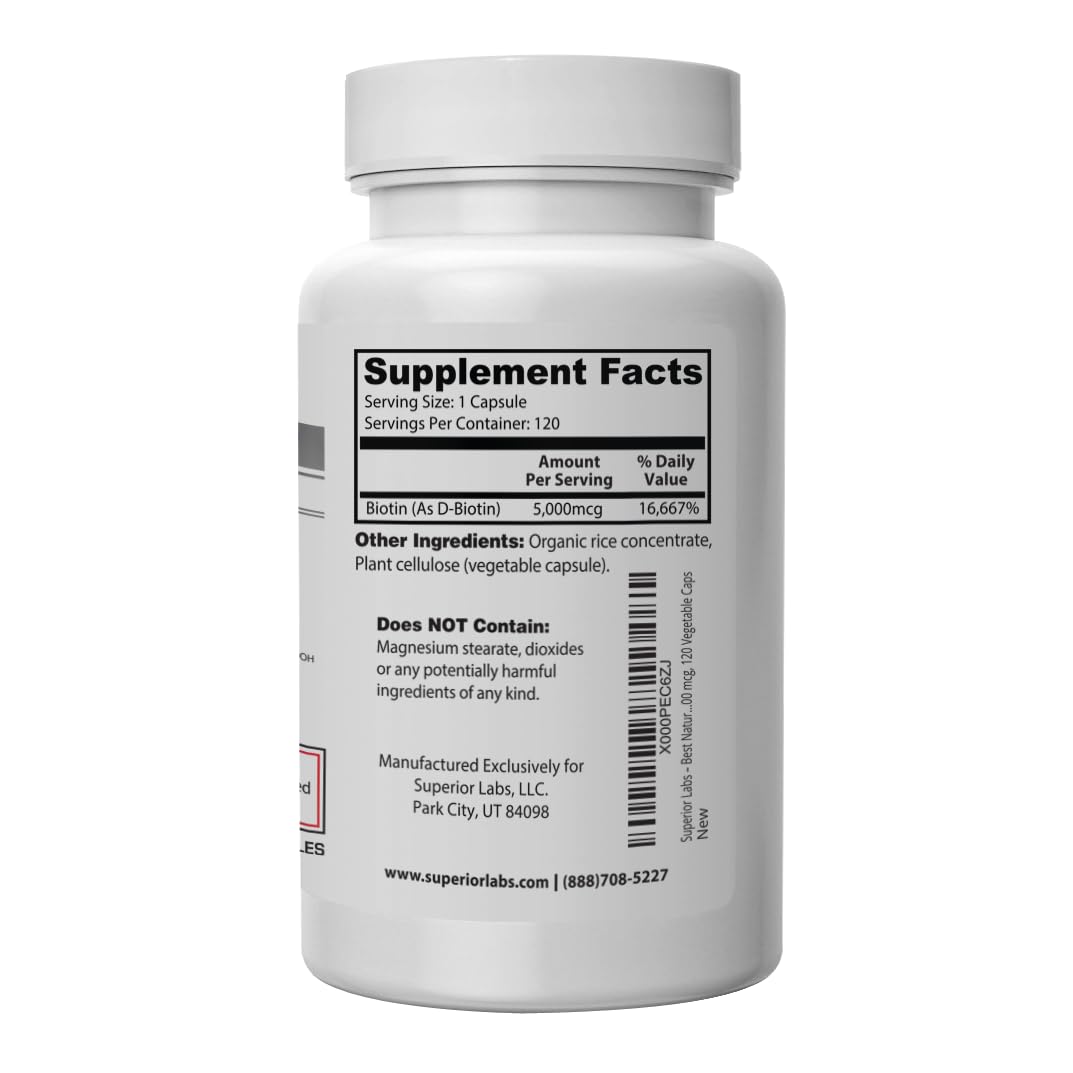 Open bottle with biotin capsules spilling onto a white surface